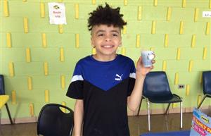 Boy student holding his planting project